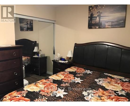 A bedroom with a large bed and a dresser.