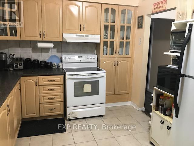 A kitchen with a white stove and wooden cabinets.