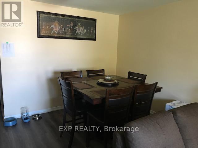 A dining room with a table set for two and a painting on the wall.