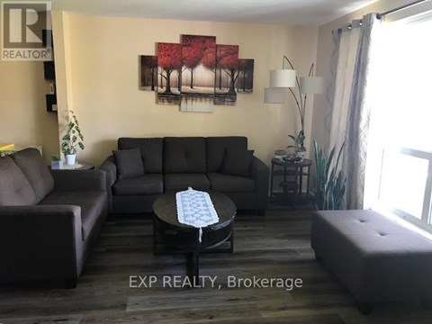 A living room with a grey couch, a coffee table, and a painting on the wall.