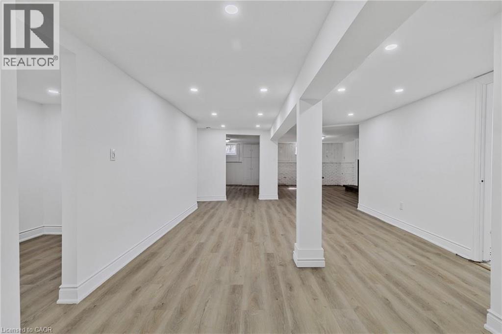 A spacious room with wooden flooring and white walls.