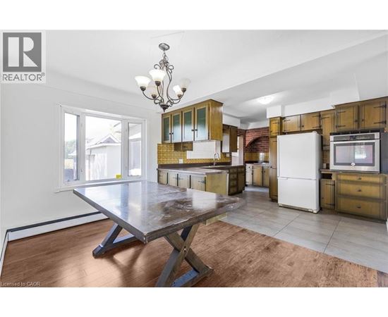 A kitchen with a table and a refrigerator.