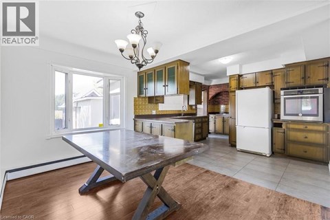 A kitchen with a table and a refrigerator.