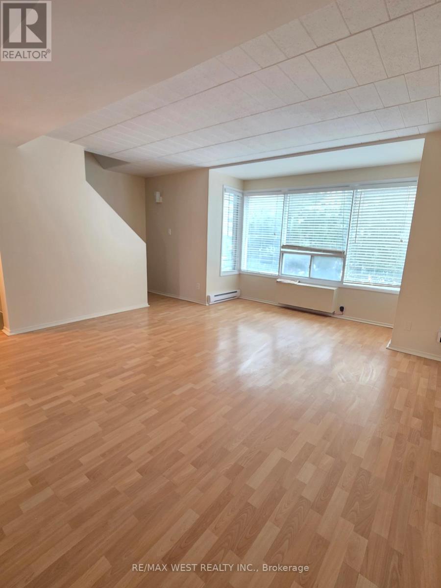 A room with wooden flooring and white walls.