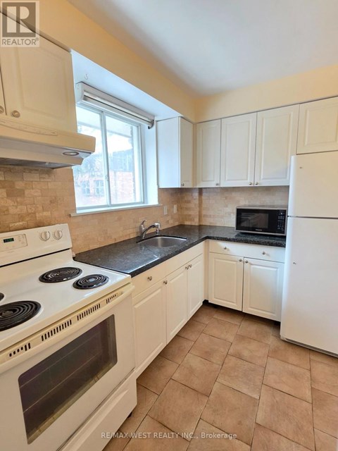 A kitchen with white appliances and cabinets.
