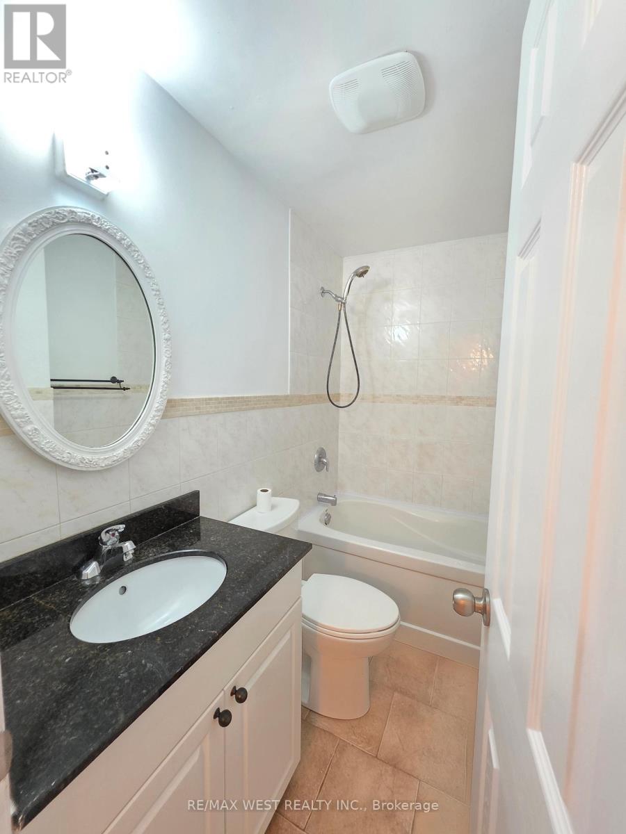A bathroom with a sink, mirror, toilet and bathtub.