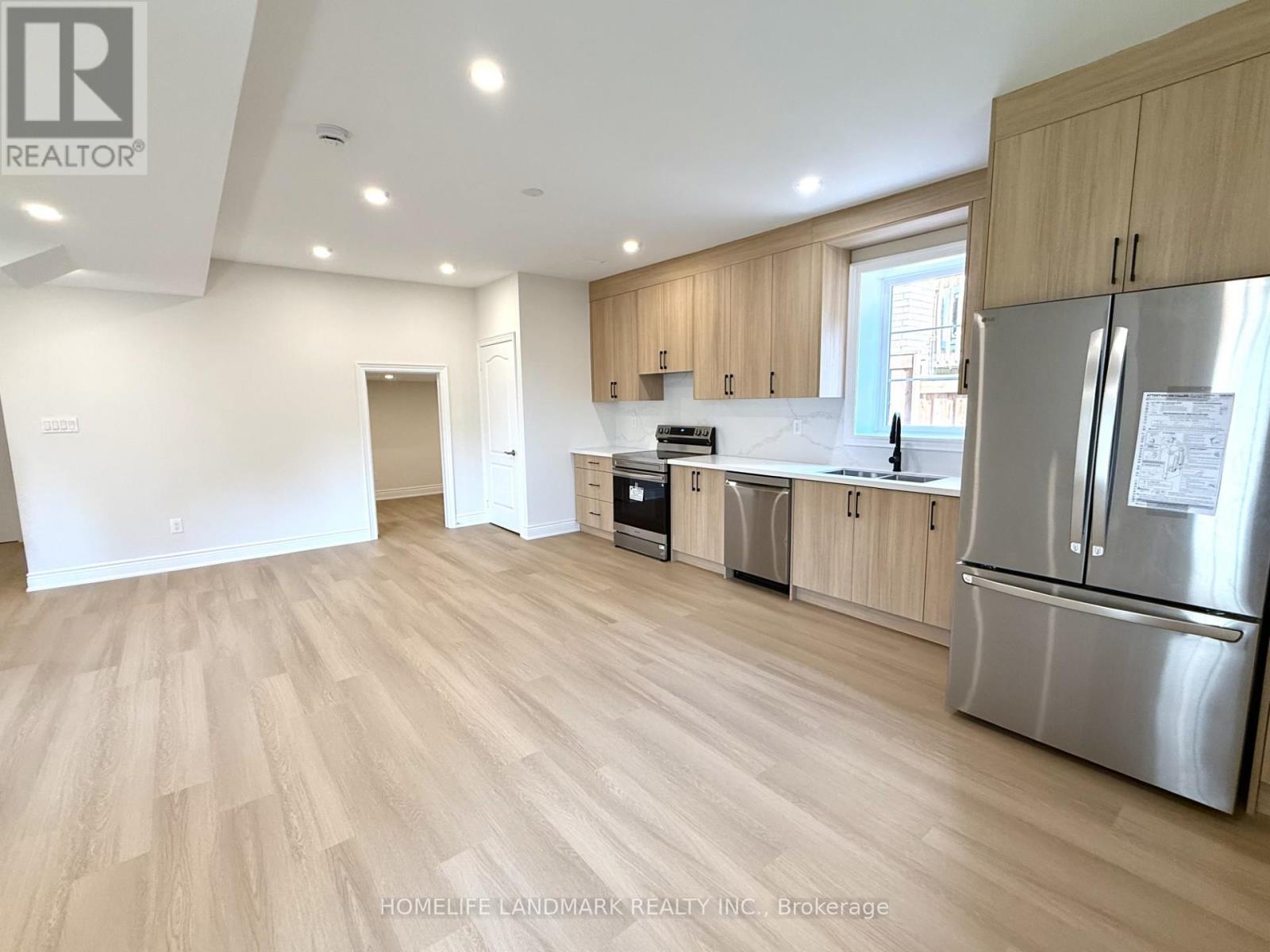 A kitchen with wooden floors and stainless steel appliances.