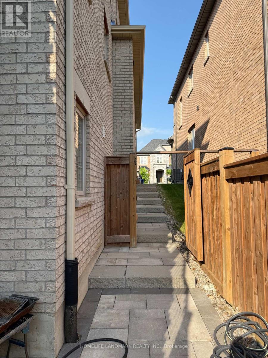 A narrow alleyway with a wooden fence on the right and a brick building on the left.