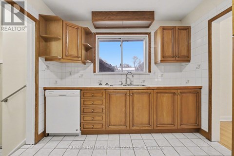 A kitchen with wooden cabinets and a white dishwasher.