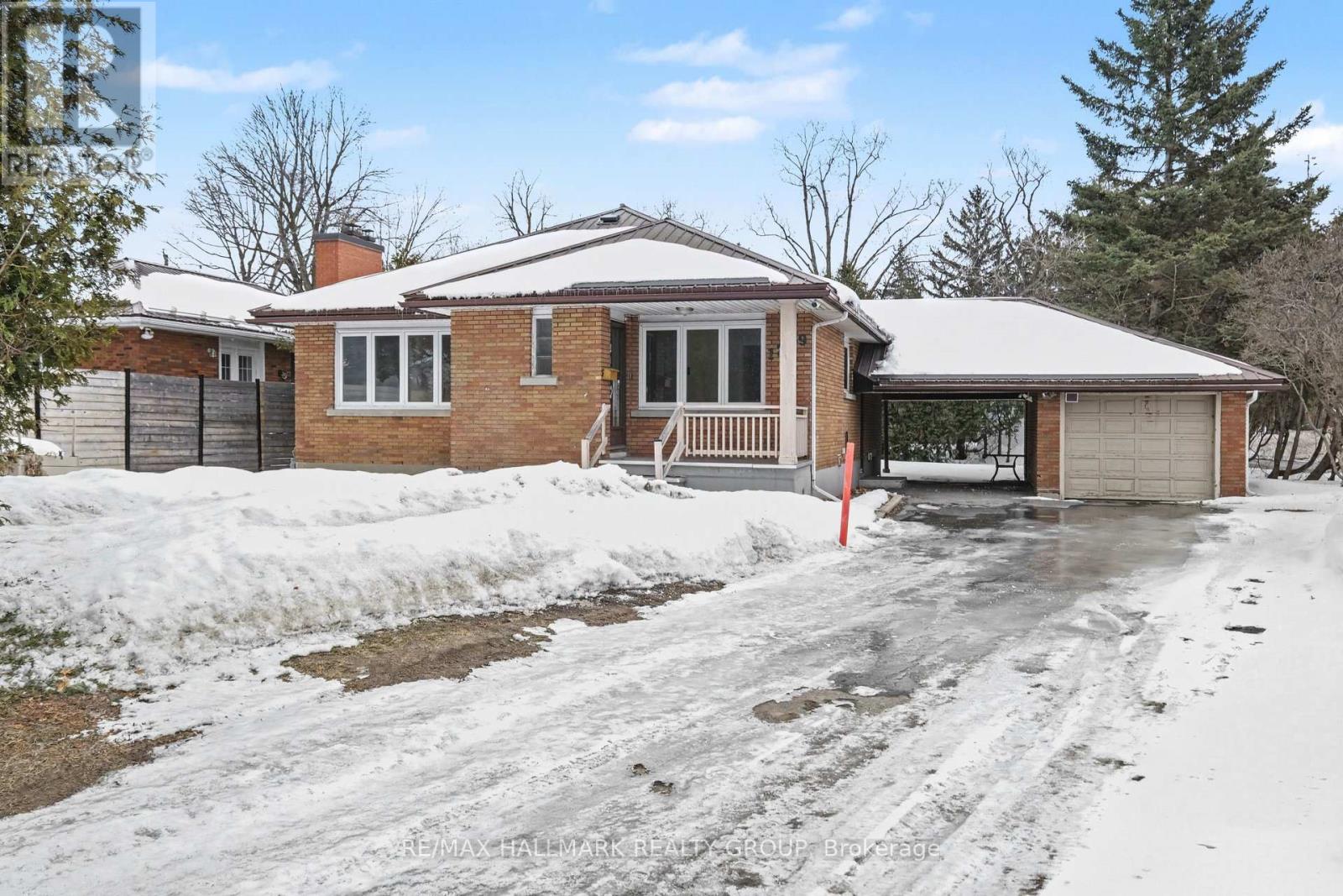 A house with a snow-covered driveway in front.