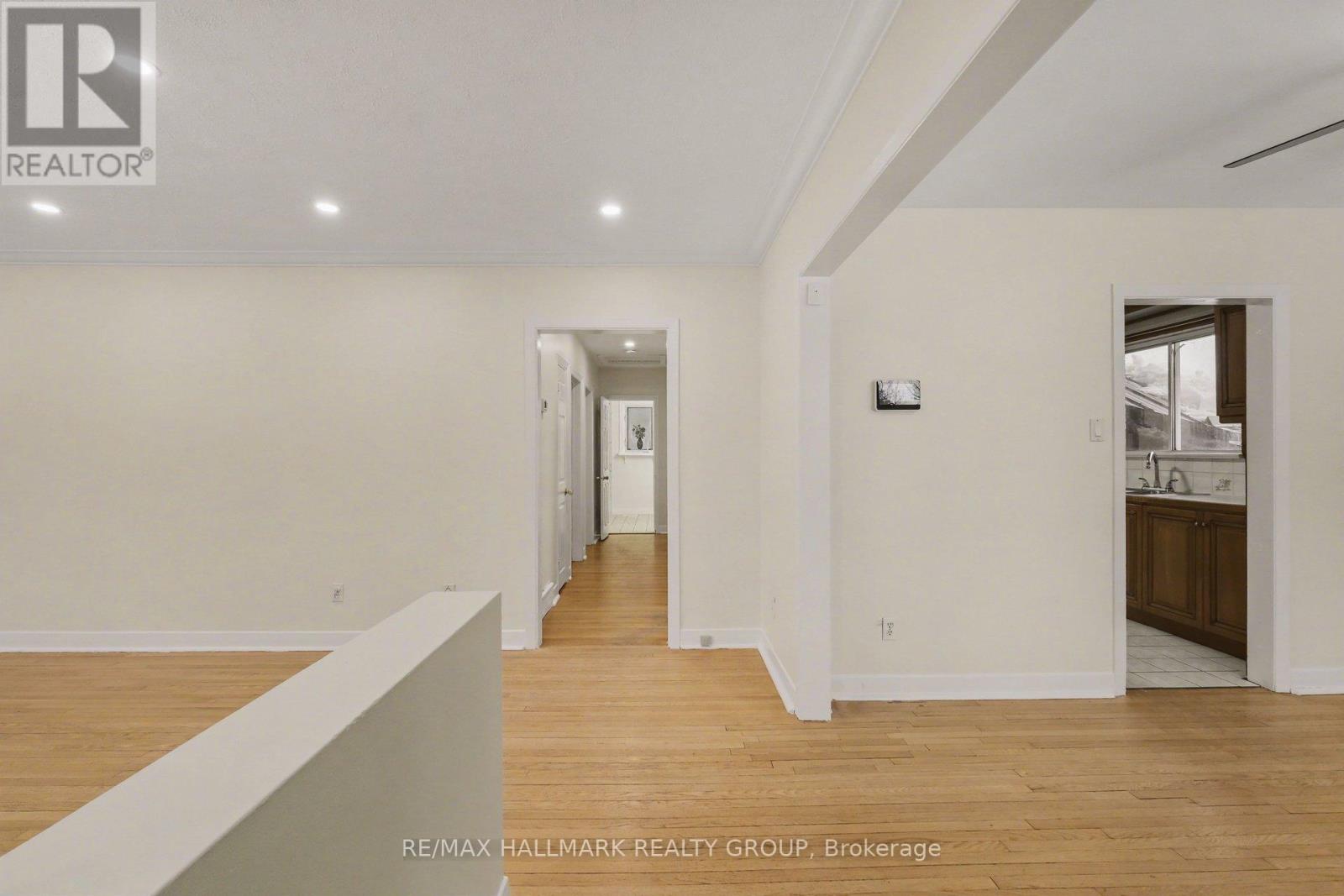 A spacious room with wooden floors and white walls.