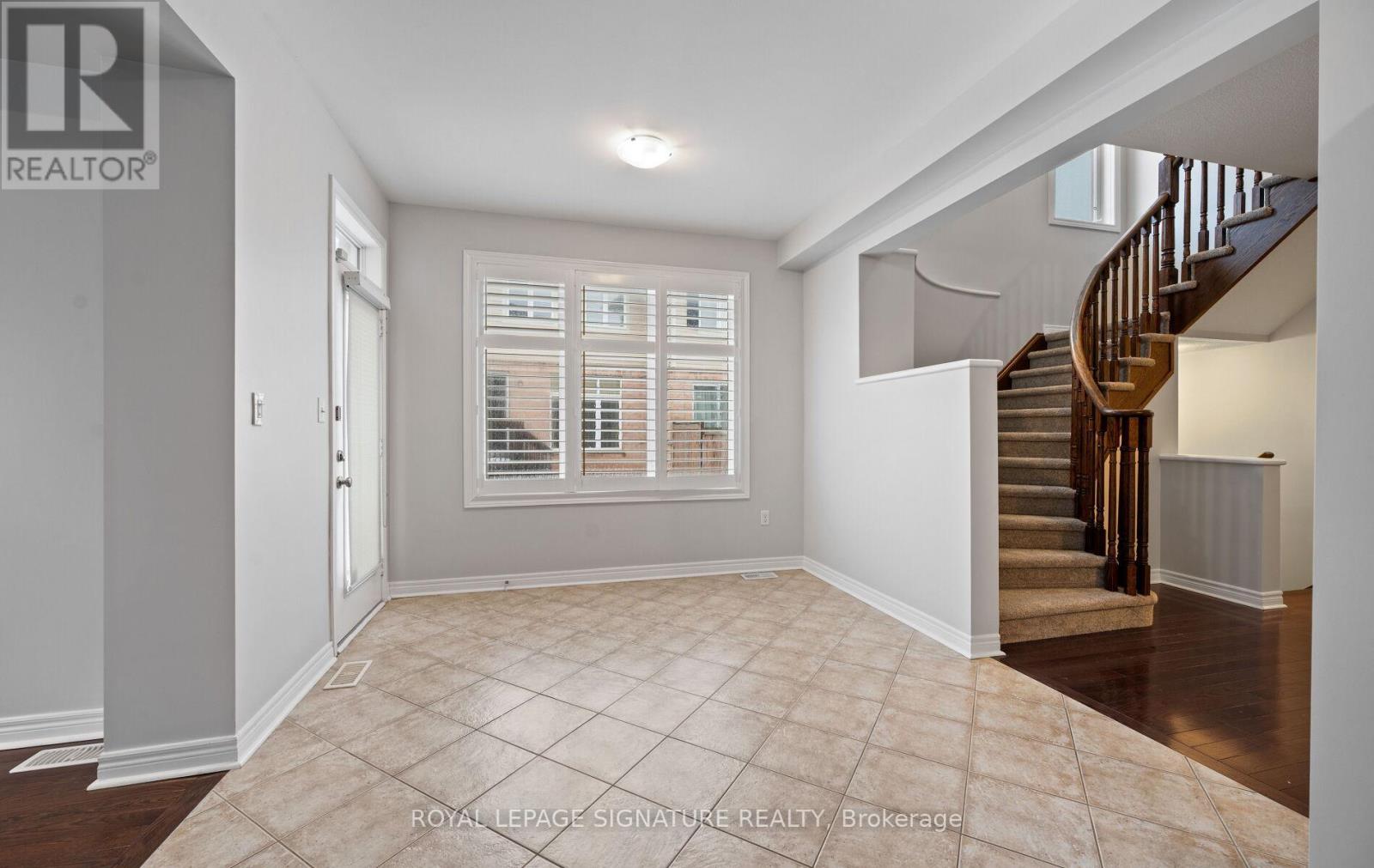 A spacious room with a staircase leading to the upper floor.