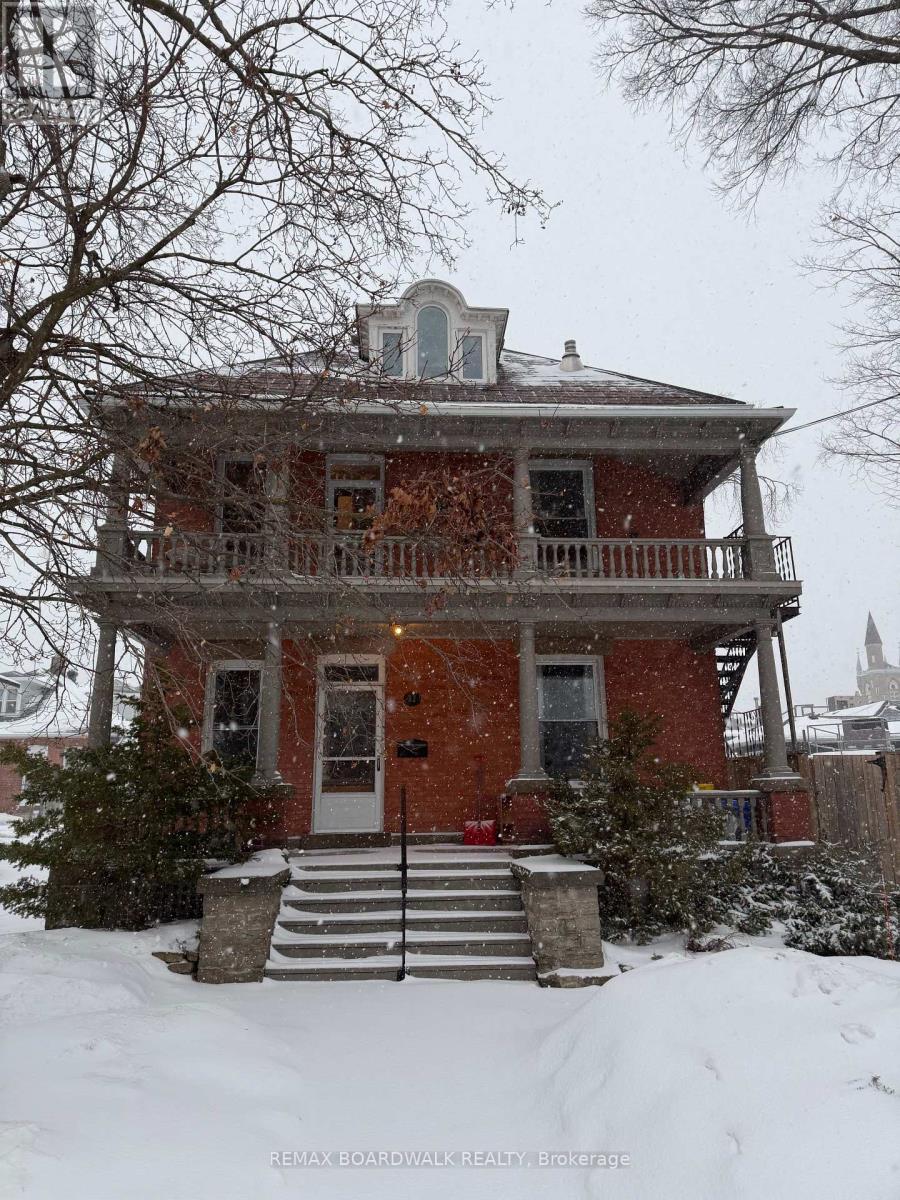 A red brick house with a balcony and a small tower on the roof.