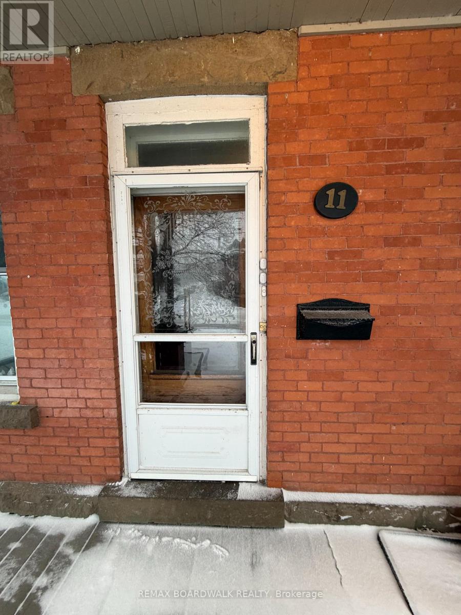 A white door with a black mailbox on a red brick wall.