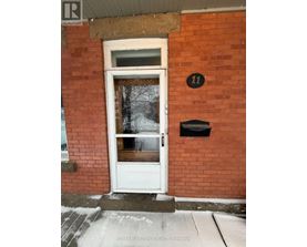A white door with a black mailbox on a red brick wall.