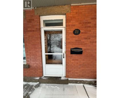 A white door with a black mailbox on a red brick wall.
