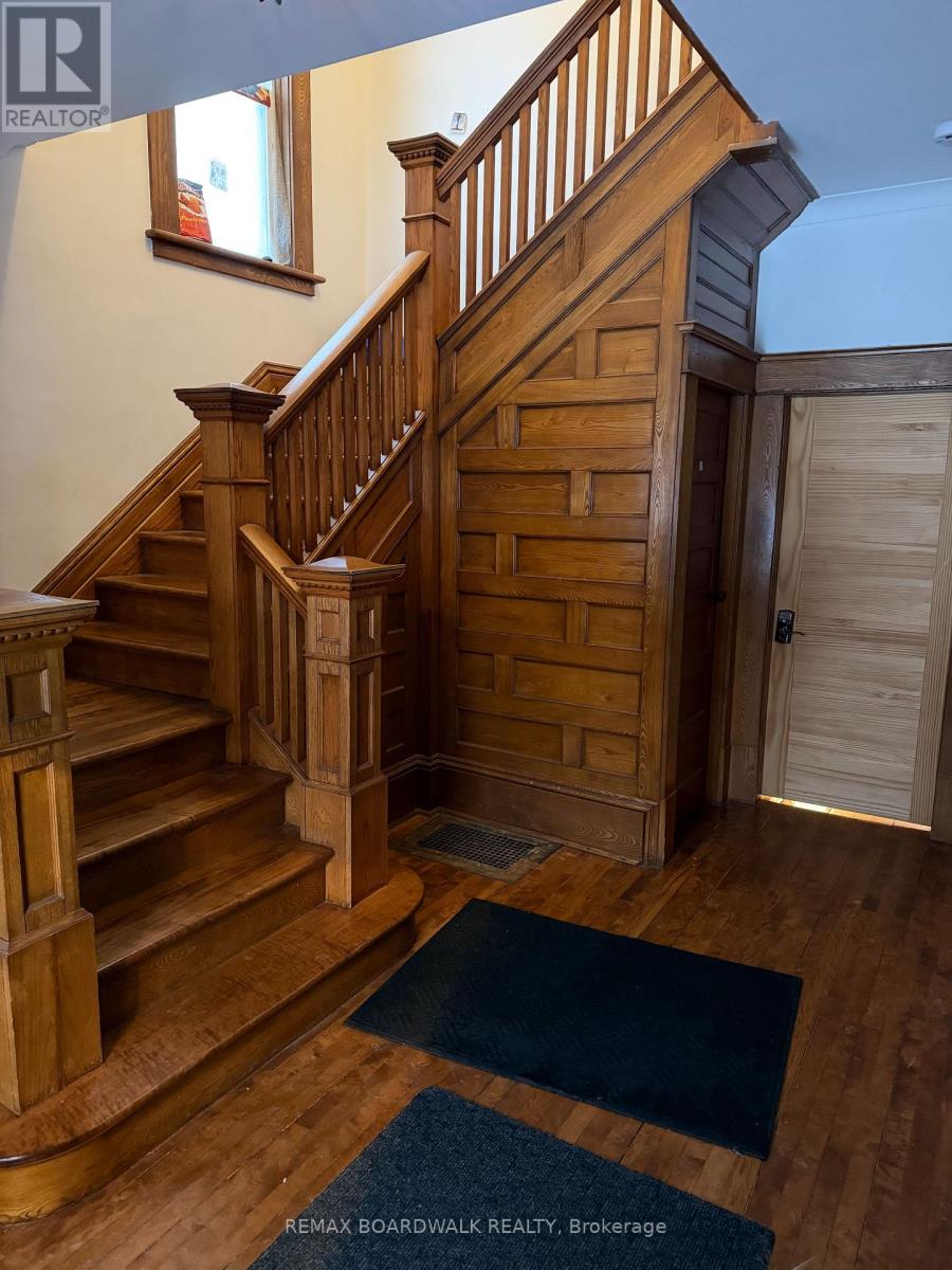 A wooden staircase with a blue rug in front of it.