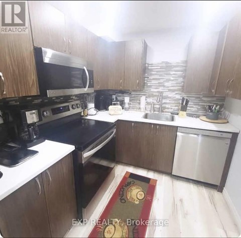 A kitchen with wooden cabinets and stainless steel appliances.