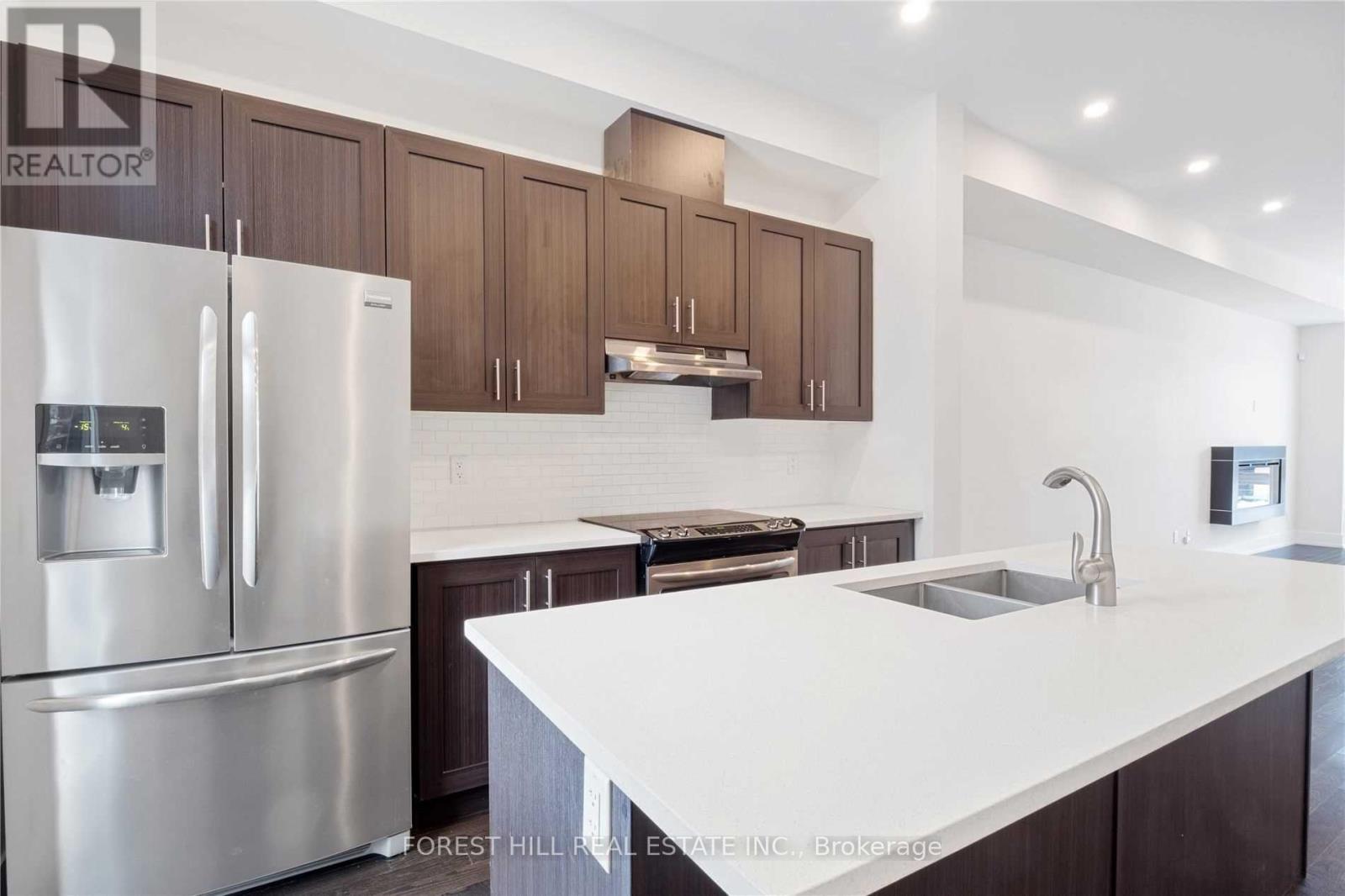 A modern kitchen with a stainless steel refrigerator and wooden cabinets.