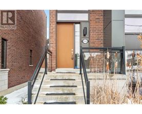 A brown door is on the right side of a brick building.