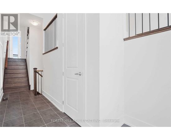 A hallway with a staircase and a white door.