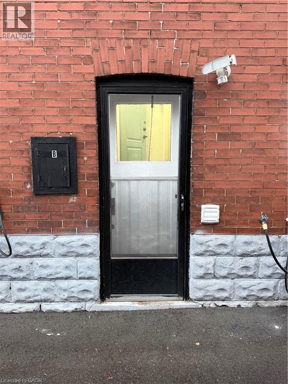 A black door with a glass window and a security camera above it.
