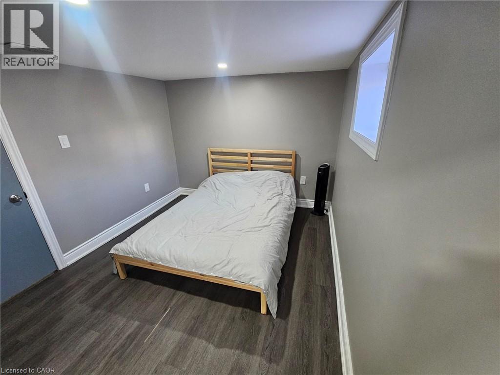 A bedroom with a bed, nightstand, and window.