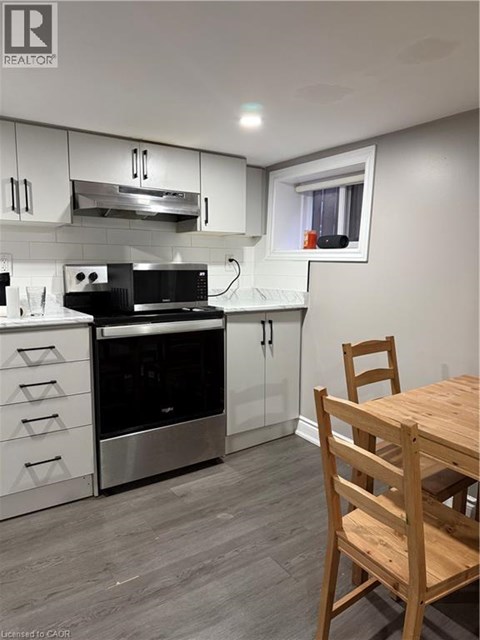 A kitchen with a wooden table and chairs.