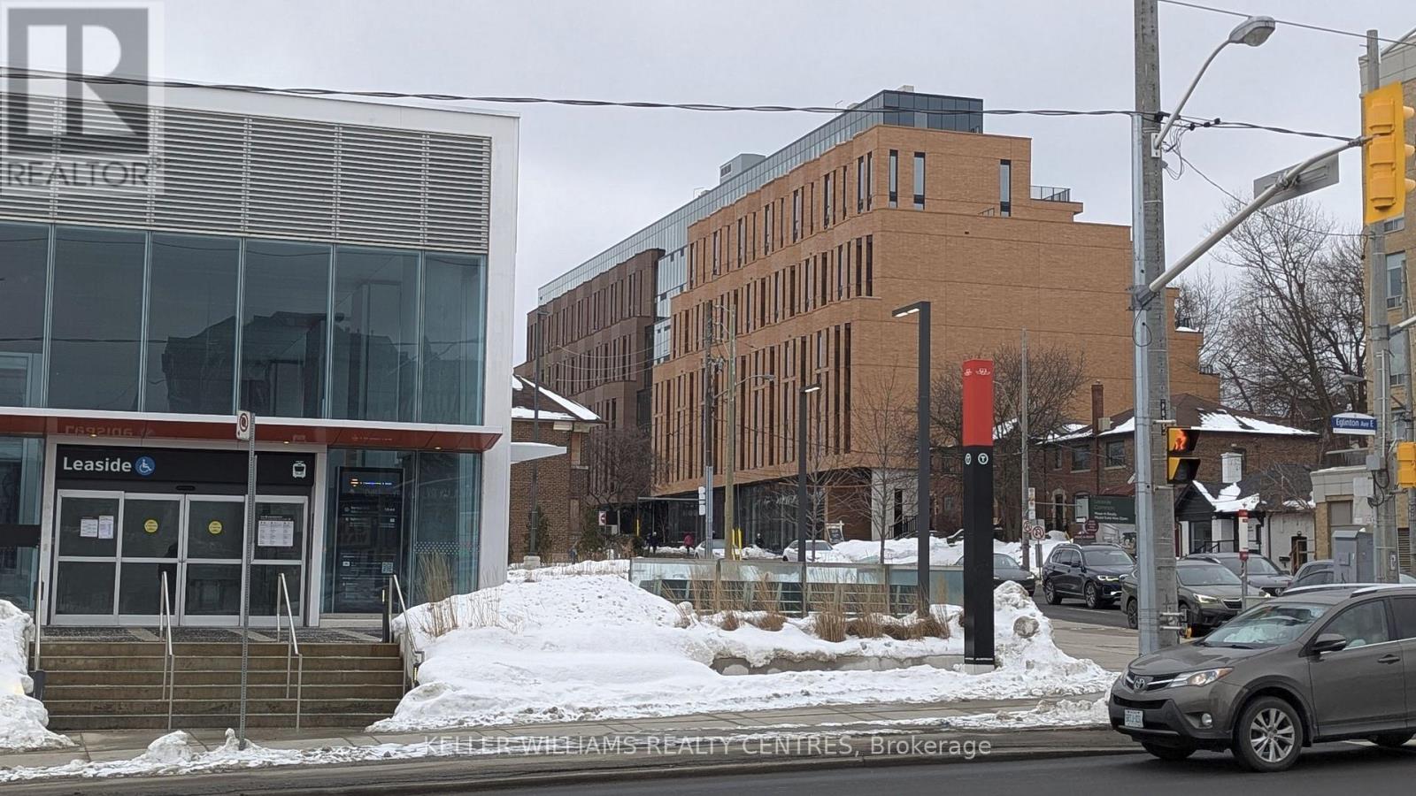 A street view with a building that has a glass entrance and a sign that says Leaside.