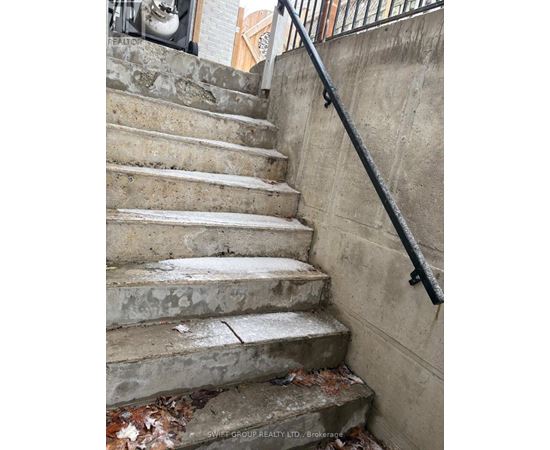 A concrete staircase with a metal handrail.