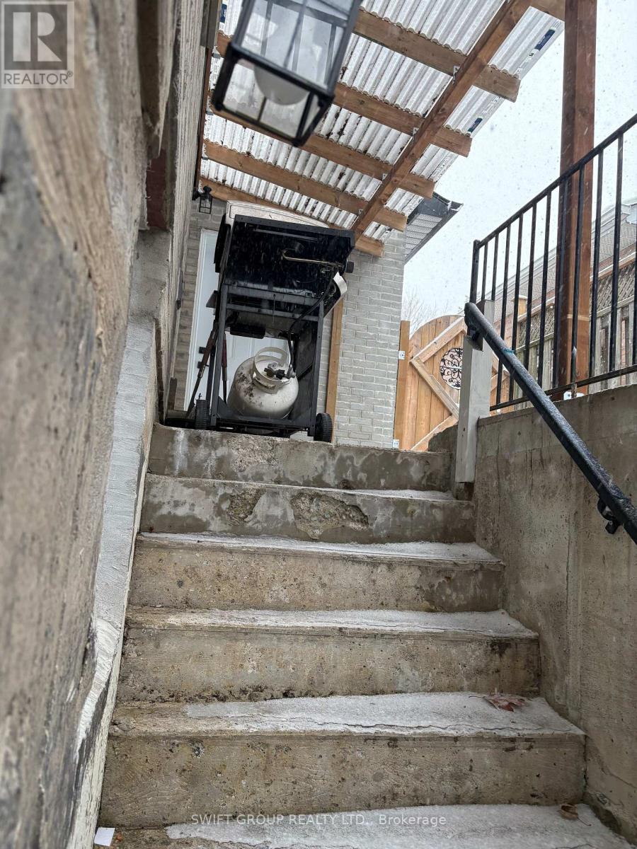 A staircase with a metal railing and a concrete wall.