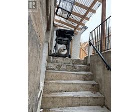 A staircase with a metal railing and a concrete wall.