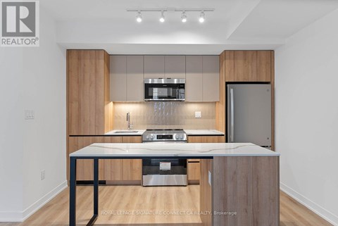 A modern kitchen with wooden cabinets and stainless steel appliances.