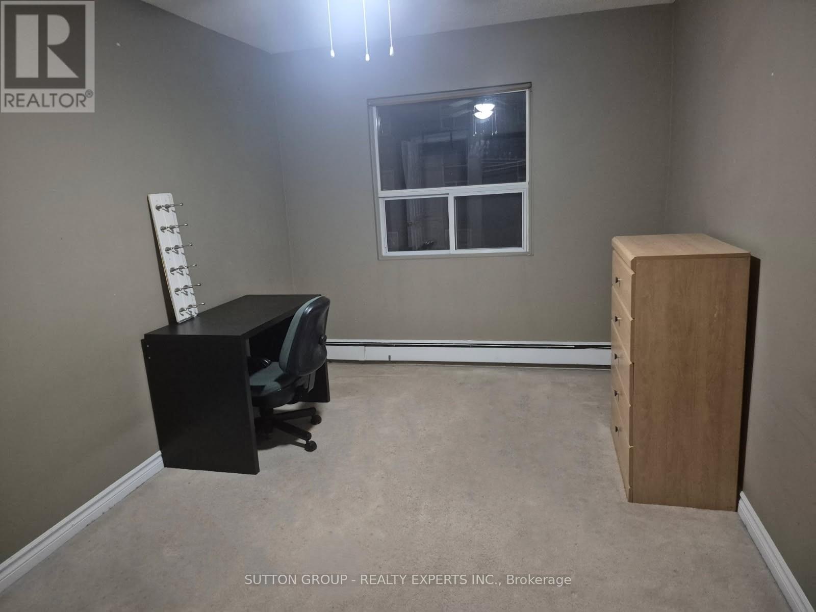 A room with a desk, chair, and a window.