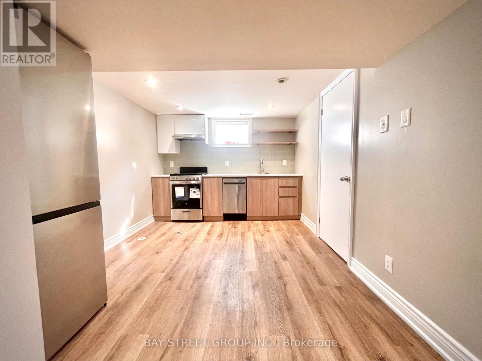 A kitchen with a refrigerator, oven, and microwave.