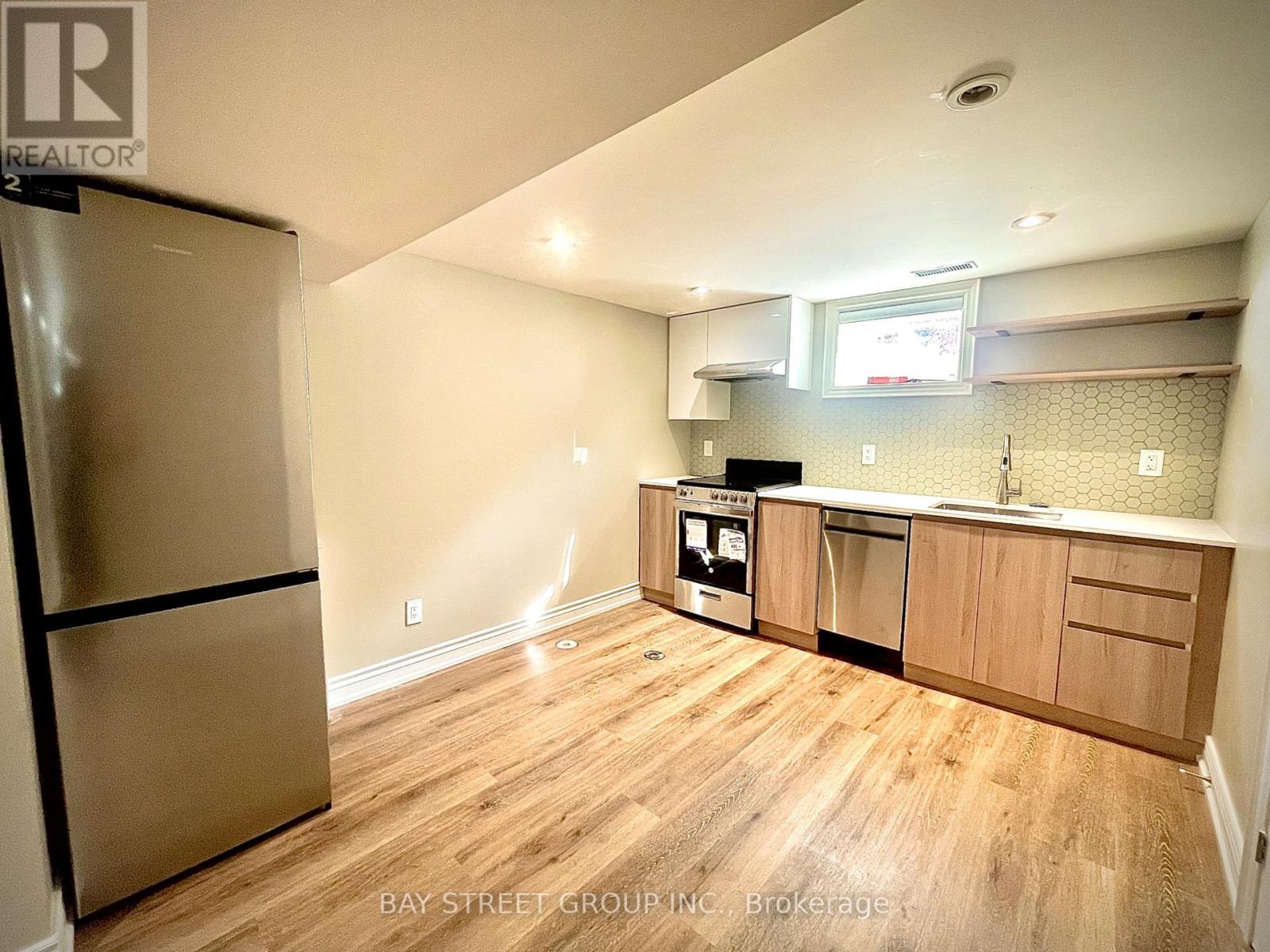 A kitchen with wooden floors and a refrigerator.