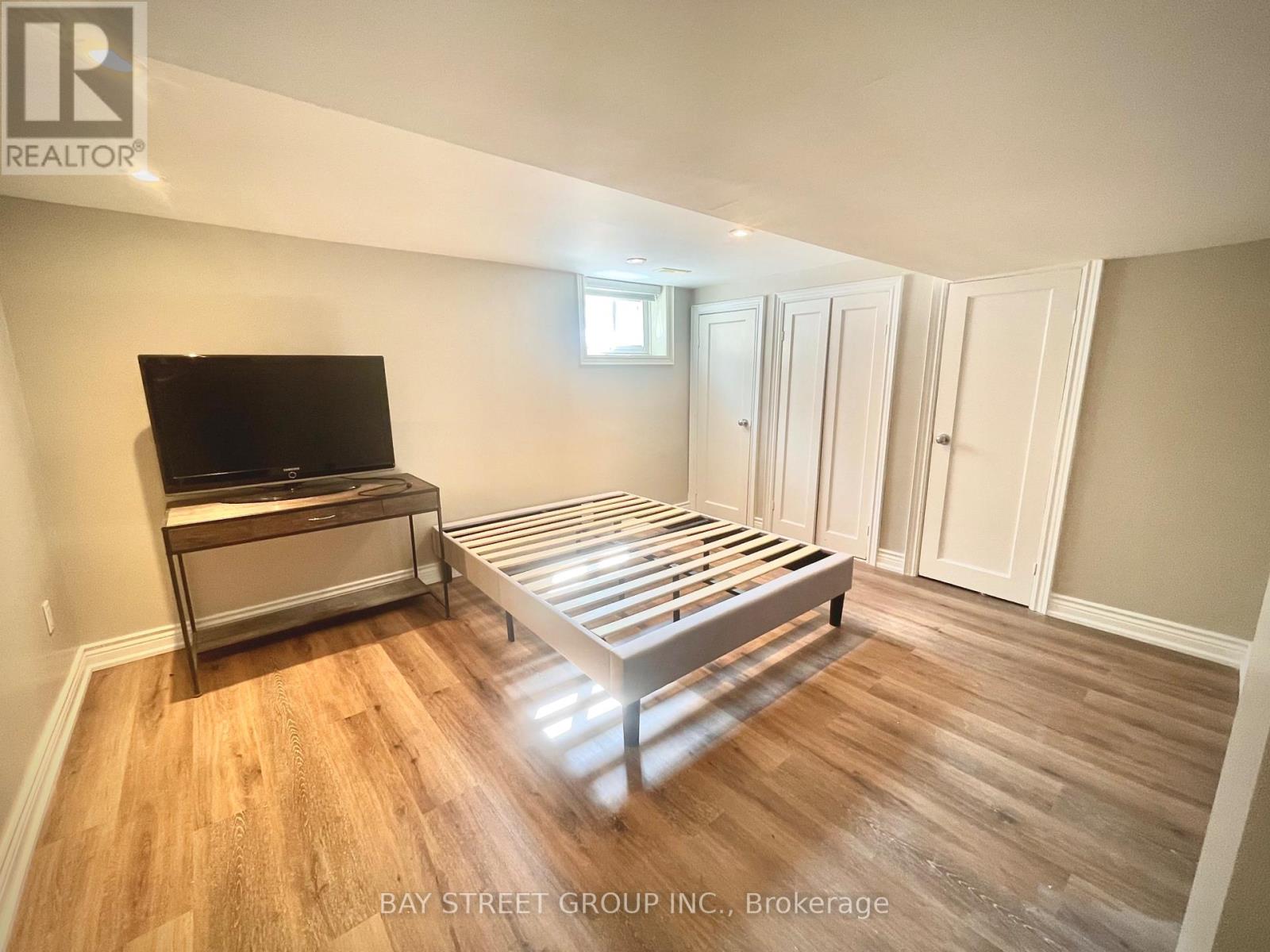 A bedroom with a bed, dresser, and television.