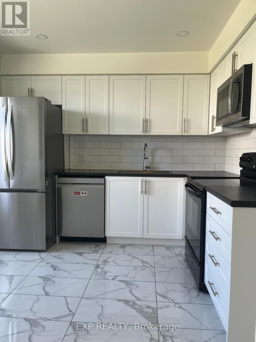A kitchen with white cabinets and a marble floor.