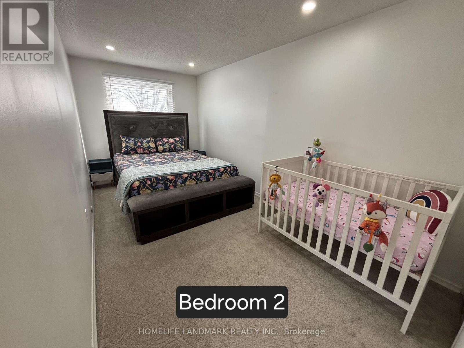 A bedroom with a bed and a crib.