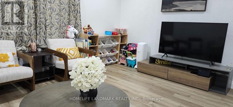 A living room with a flat screen TV and a coffee table with flowers on it.