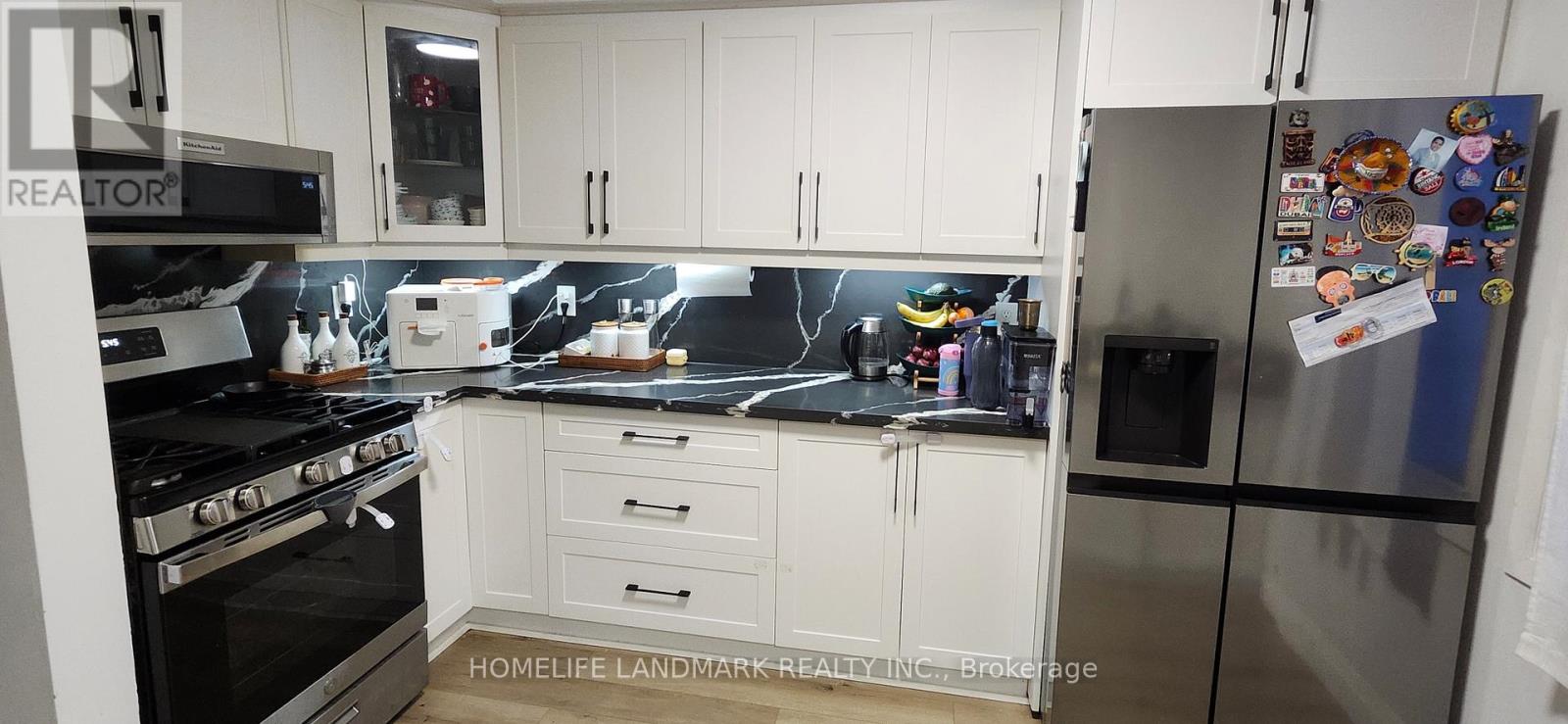 A kitchen with a refrigerator covered in magnets and a stove top oven.
