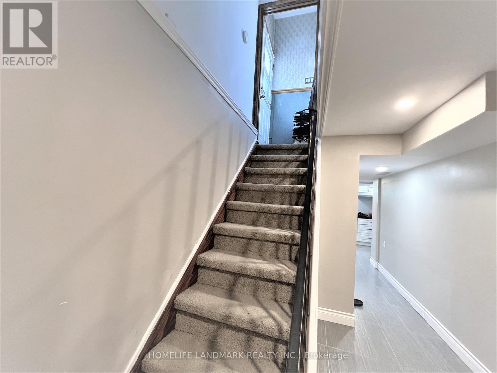 A staircase with a carpeted runner leads to a doorway.