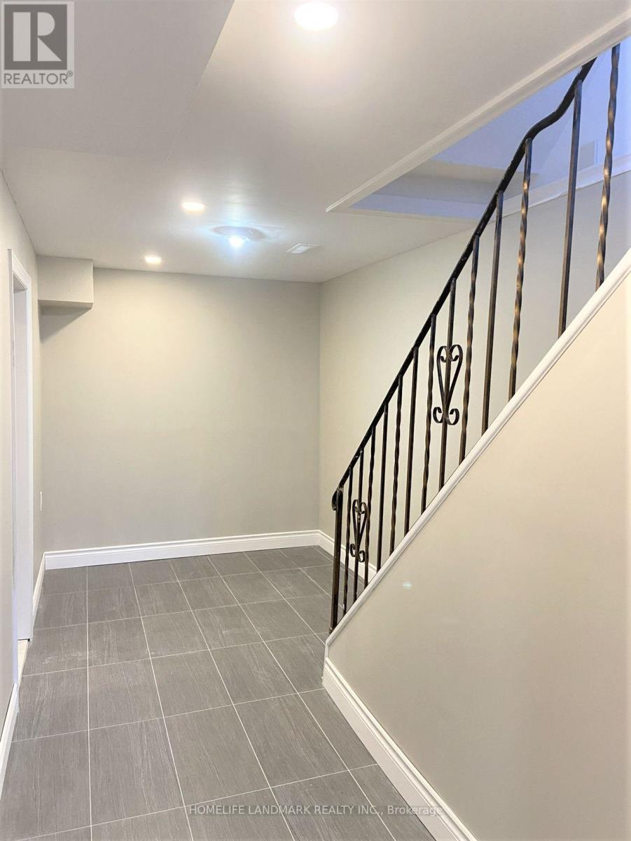 A hallway with a staircase and tiled floor.