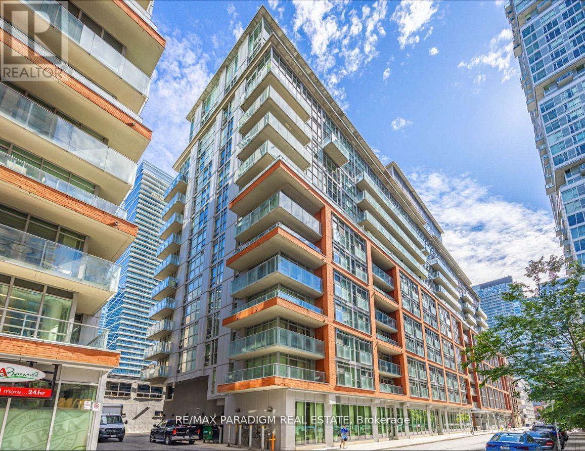 A tall residential building with balconies and a sign that reads RE/MAX Paradigm Real Estate.