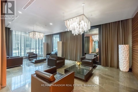 A modern living room with a glass table and brown leather couches.