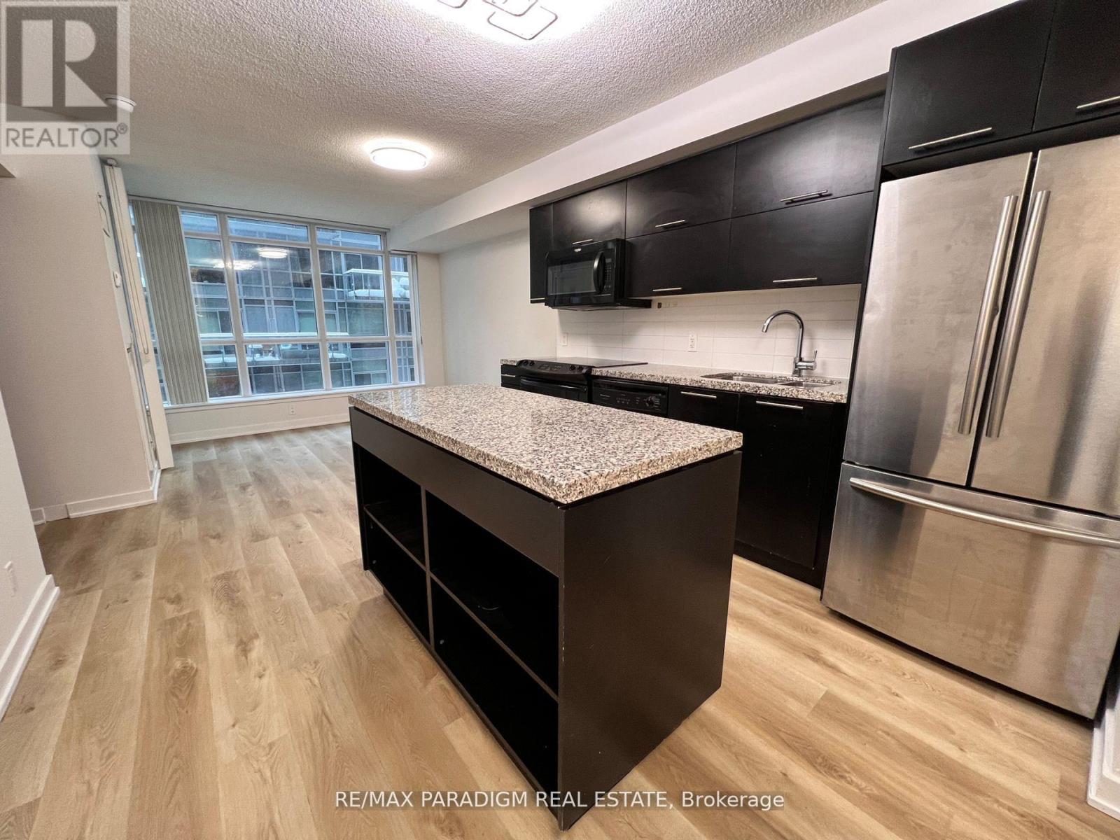 A kitchen with a granite countertop and stainless steel appliances.