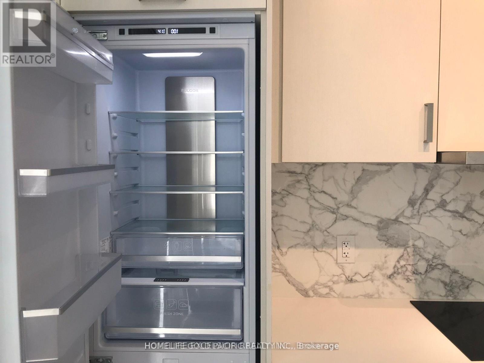 A refrigerator with the door open showing the empty shelves.