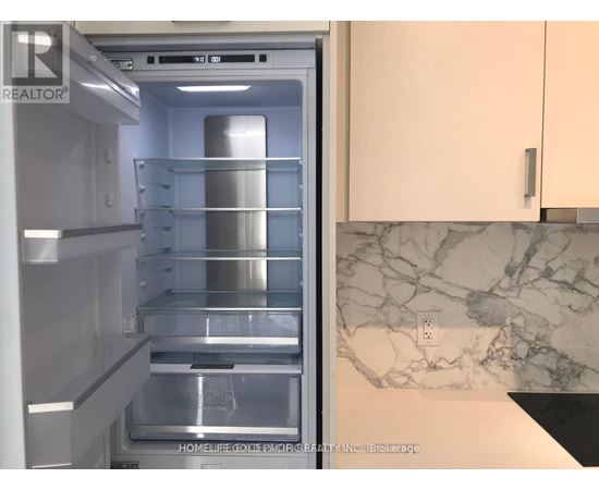 A refrigerator with the door open showing the empty shelves.
