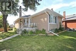 A house with a white fence and a green lawn.