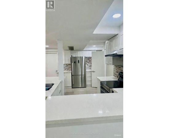 A modern kitchen with white cabinets and a marble countertop.